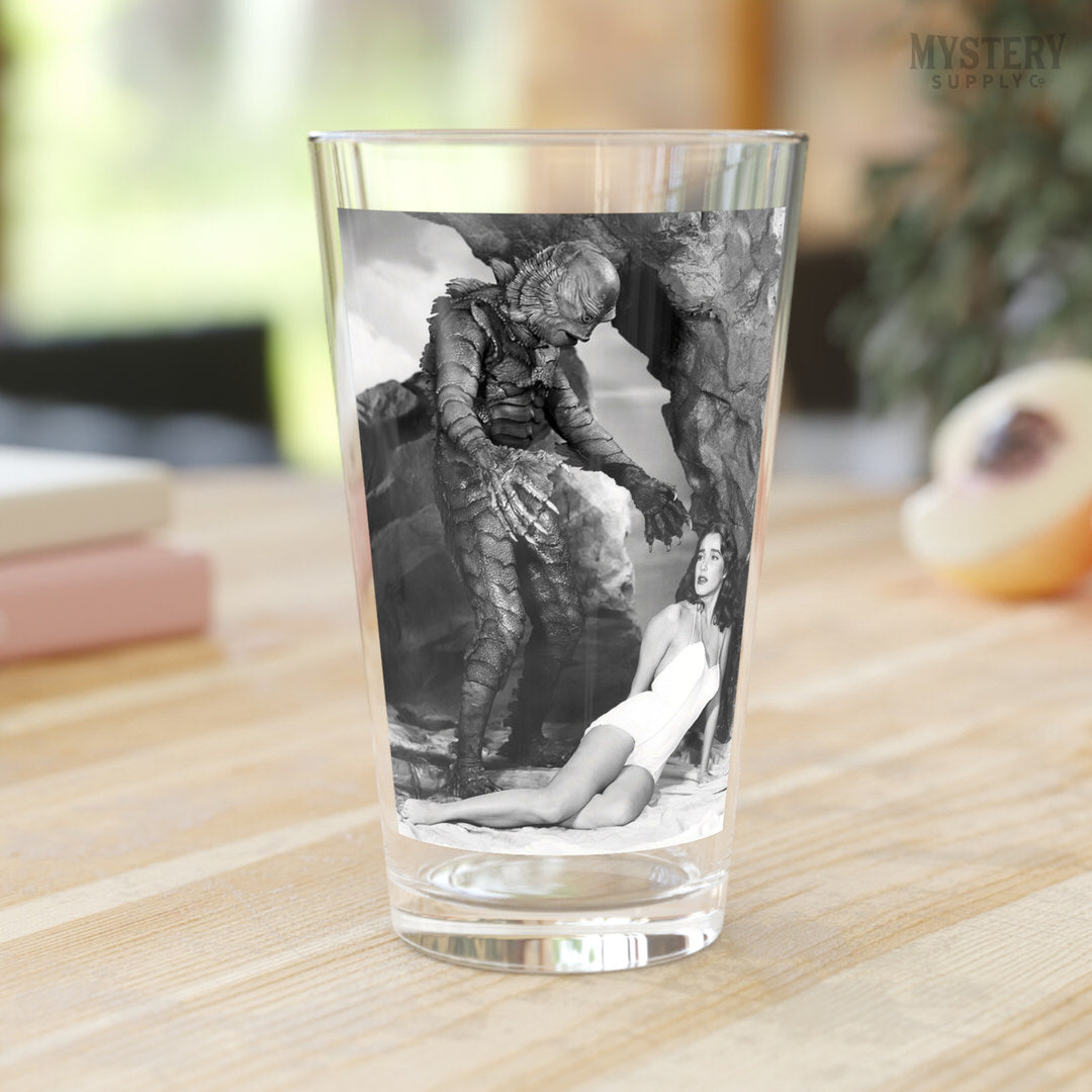 Creature from the Black Lagoon 1954 vintage horror monster Julie Adams swim suit and the gill man black and white photo reproduction 16oz pint glass home decor glassware from Mystery Supply Co. @mysterysupplyco