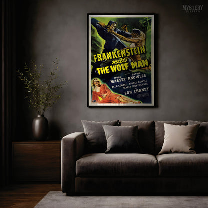 A framed vintage movie poster for 'Frankenstein meets The Wolf Man' displayed on a dark gray wall above a modern dark gray sofa in a dimly lit living room. From Mystery Supply Co.