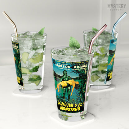 Three glasses of iced drinks with movie poster-themed labels on a white surface. Creature from the Black Lagoon 1954 vintage Spanish Gill Man horror monster movie poster reproduction 16oz clear pint glass home decor glassware from Mystery Supply Co. @mysterysupplyco
