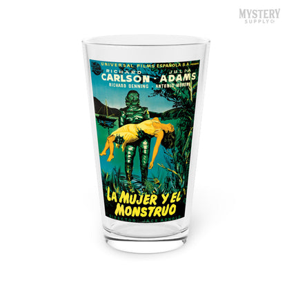 Glass with a movie poster design featuring a creature and text on a white background. Creature from the Black Lagoon 1954 vintage Spanish Gill Man horror monster movie poster reproduction 16oz clear pint glass home decor glassware from Mystery Supply Co. @mysterysupplyco