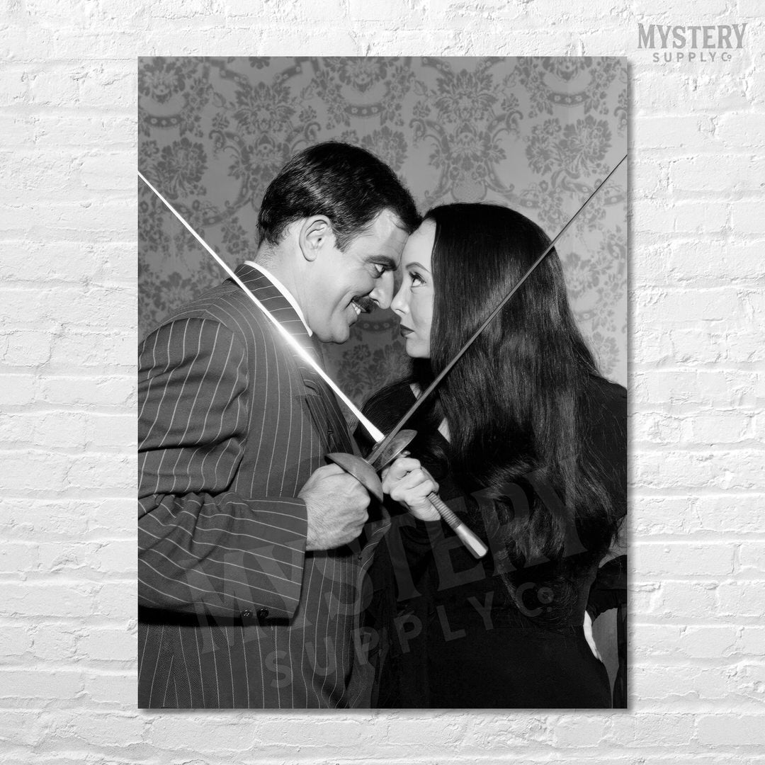 Morticia and Gomez Fencing 1960s Vintage Addams Family Black and White Photo Reproduction wall decor art print from Mystery Supply Co. @mysterysupplyco