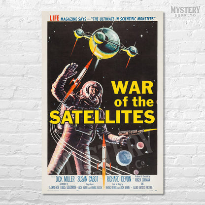 Vintage-style movie poster for 'War of the Satellites' with an astronaut and satellite on a white brick wall. From Mystery Supply Co. @mysterysupplycobackground.